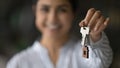 Blurred portrait of young female realtor holding key in hand Royalty Free Stock Photo