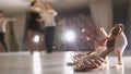 Blurred professional man and woman dancing Latin dance in costumes in the Studio, ballroom shoes in the foreground