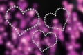 Blurred purple background with 3 hearts of rhinestones