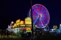 Blurred purple lights on ferris wheel by carnival food vendors at county fair Royalty Free Stock Photo