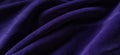 Blurred purple textile background. Soft smooth lines, velvety fabric structure. Black and purple colors