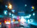 Blurred rain drops on car window with road light bokeh on rainy season abstract background Royalty Free Stock Photo