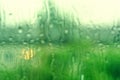 Blurred rain drops on a window background. Nature green bokeh