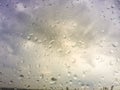 Blurred raindrops on window glass, background,rainy season. Rain drops on window glasses surface with cloudy background . Natural Royalty Free Stock Photo