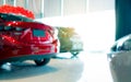 Blurred rear view of red car. Luxury car parked in modern showroom. Car dealership office. Automobile retail shop. Electric and Royalty Free Stock Photo