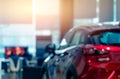 Blurred rear view of red car. Luxury car parked in modern showroom. Car dealership office. Automobile retail shop. Electric and Royalty Free Stock Photo