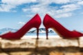 Blurred red shoes stand on a stone against the background of the sea Royalty Free Stock Photo