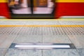 Blurred red subway train in Warsaw Poland, tactile paving for vi