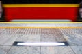 Blurred red subway train in Warsaw Poland, tactile paving for vi