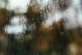 Blurred reflection of the street in a misted window, drops of water after rain flow down the glass. Water drops on window. Rainy Royalty Free Stock Photo