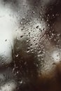 Blurred reflection of the street in a misted window, drops of water after rain flow down the glass. Water drops on window. Rainy Royalty Free Stock Photo