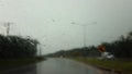 Blurred of Road view from car window on the highway with dark clouds and rain drops Royalty Free Stock Photo