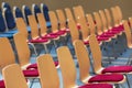 Blurred rows of empty wooden chairs in a large assembly hall.Empty chairs in conference hall.Interior meeting room. Royalty Free Stock Photo