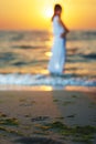 Blurred sandy beach with green seaware near waves.