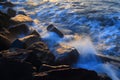 Blurred sea wave crashing over rocks Royalty Free Stock Photo