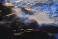 Blurred sea wave crashing over rocks Royalty Free Stock Photo