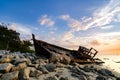 Silhouette image of abandon shipwrecked on rocky shoreline. dark cloud and soft on water Royalty Free Stock Photo