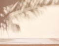 Blurred shadow of tropical palm leaves on beige wall and table top in the foreground. Summer concept