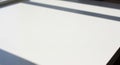 Blurred shadows of a window frame cast across a smooth, white surface, suggesting sunlight Royalty Free Stock Photo