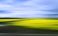 Blurred and shaken image of a landscape in shades of green, yellow and blue.