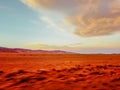 A blurred, shaky view of an empty desert sand ground landscape with cloudy sky, clicked while travelling in car to give motion blu