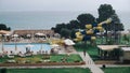 Blurred Shot Of Hotel Area With Pool And Water Slide During Rain. Sunbeds Are Empty, People Are Fleeing From Rain Under