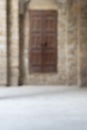 Blurred shot of old abandoned stone bricks wall with grunge weathered wooden door Royalty Free Stock Photo