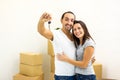 Blurred shot of young family extremely happy because they bought a new house. Man showing keys to the camera. Royalty Free Stock Photo
