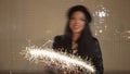 Blurred shot of young woman having fun with sparkler in her hands in night city, light painting, retro color, defocused Royalty Free Stock Photo
