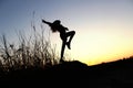 Blurred silhouette of young slender girl posing over beautiful sunset background. Royalty Free Stock Photo