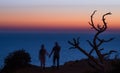 Blurred silhouettes of a couple holding hands on a sunset sea background Royalty Free Stock Photo