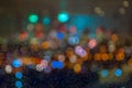 Blurred skyline with bokeh effect seen behind a wet window with raindrops