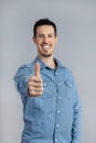 Blurred Man in studio in denim shirt showing thumb up with hand copy-space