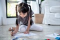 Asian baby girl sitting on the floor, are concentrating make art by using colored pencils