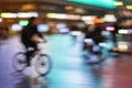 Blurred style background of silhouette of abstract unrecognizable man, riding bike, night city, illumination bokeh Royalty Free Stock Photo