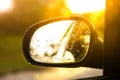 Blurred sunshine reflection of road in the side view mirror with raindrops. Travel concept Royalty Free Stock Photo