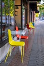 Blurred tables and chairs in the street. Colored chairs and tables, at outdoor coffee shop. Colored bistro chairs