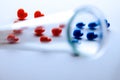A blurred test tube in the foreground closes the letters IVF from red and blue hearts. Concept of in vitro fertilization Royalty Free Stock Photo