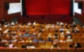 Blurred theater scene with red curtains and people, blurred background image of concert hall