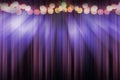 Blurred theater stage with purple curtains and spotlights, abstract image of concert lighting