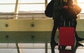 Blurred tourist with baggage walking in international airport. Airline passenger with luggage in the morning with sunrise.