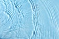 Blurred transparent blue colored clear calm water surface texture with splash and bubbles. Royalty Free Stock Photo