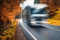 Blurred truck on the road in autumn foggy forest in rainy day Royalty Free Stock Photo