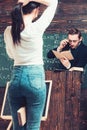 Blurred turn back girl holding a book between her legs and making a ponytail. Professor reading from book while standing Royalty Free Stock Photo