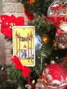 Blurred vertical banner with Tarot card near Christmas decoration.