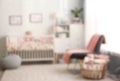 Blurred view of baby room interior with crib