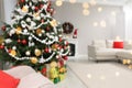 Blurred view of beautiful Christmas tree in stylish living room interior. Bokeh effect Royalty Free Stock Photo