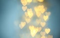 Blurred view of beautiful gold heart shaped lights on blue background Royalty Free Stock Photo