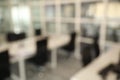 Blurred view of cozy workspaces with tables and chairs in office