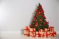 Blurred view of decorated Christmas tree and gift boxes near light wall Royalty Free Stock Photo